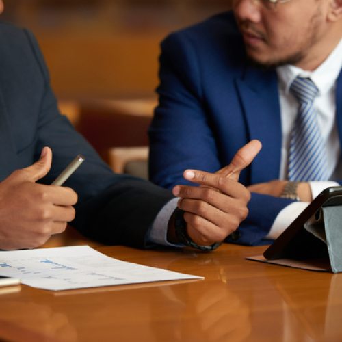 Cropped image of business people discussing financial report at meeting